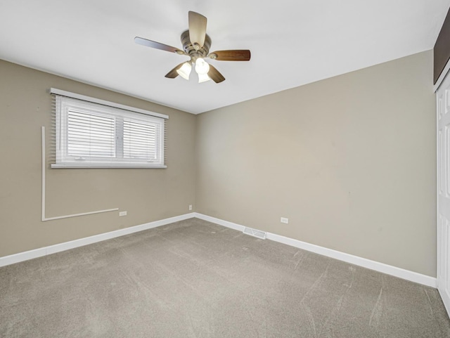 spare room featuring ceiling fan and carpet