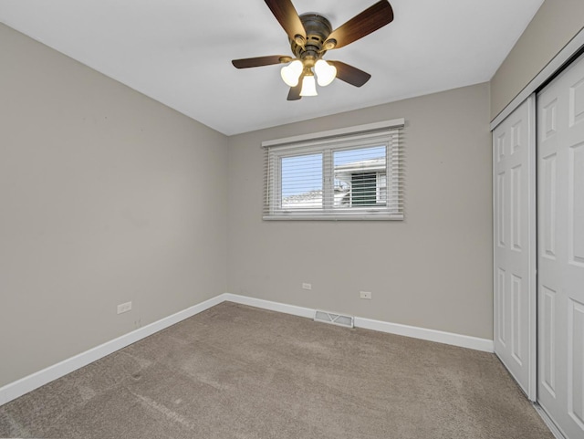 unfurnished bedroom featuring ceiling fan, a closet, and light colored carpet