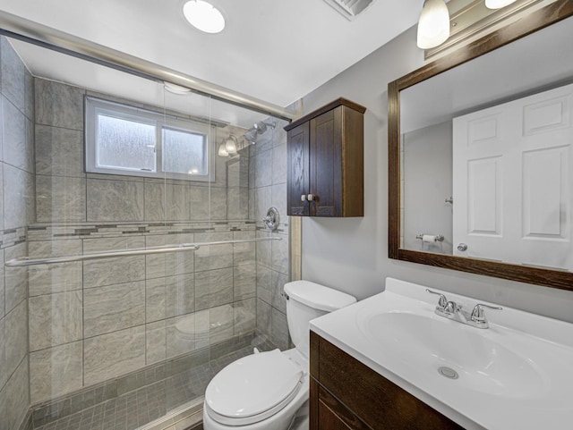 bathroom with a shower with door, vanity, and toilet