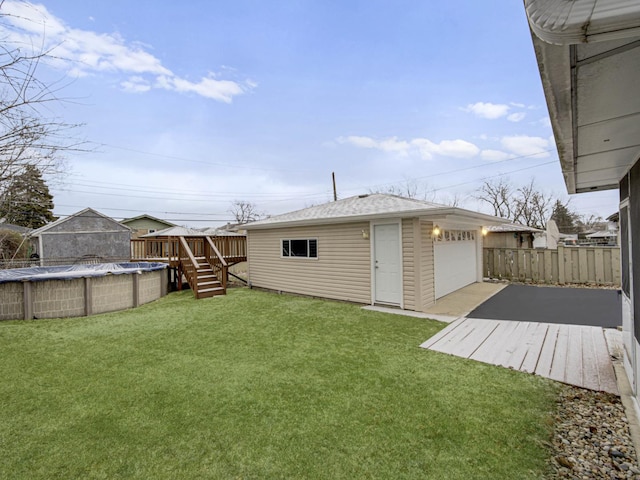 view of yard featuring an outbuilding, a swimming pool side deck, and a garage