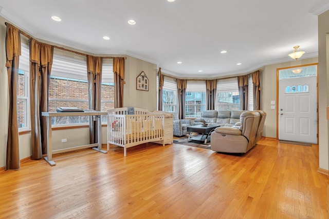 bedroom featuring light hardwood / wood-style floors, ornamental molding, and a crib