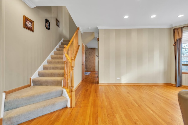 stairway featuring wood-type flooring and ornamental molding