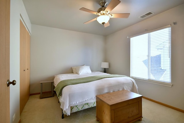 bedroom featuring ceiling fan, light colored carpet, and a closet