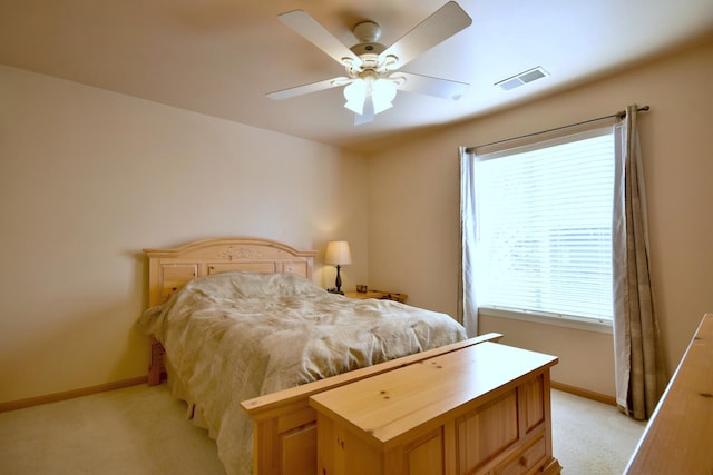 bedroom with multiple windows, light carpet, and ceiling fan