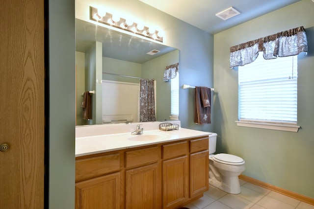 bathroom with tile patterned flooring, vanity, toilet, and walk in shower