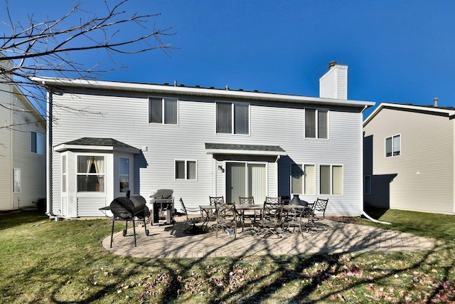 back of property with a yard and a patio