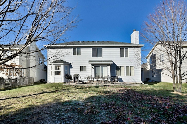 rear view of house featuring a lawn and a patio area