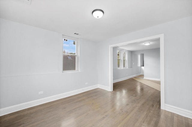 spare room with plenty of natural light and hardwood / wood-style floors