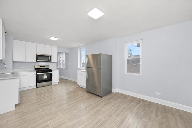 kitchen with white cabinetry, sink, and appliances with stainless steel finishes