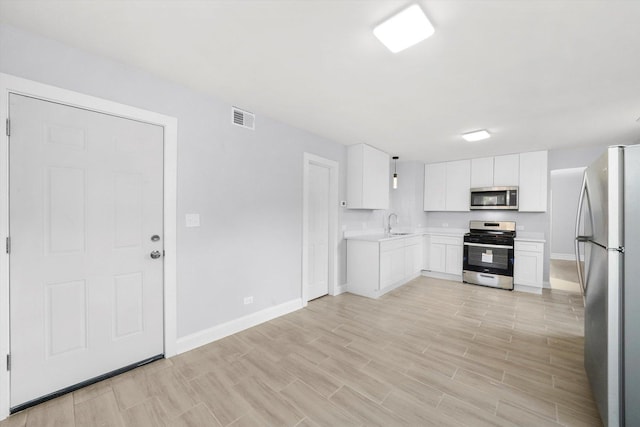 kitchen with sink, white cabinets, and stainless steel appliances