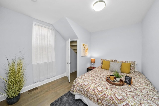 bedroom with hardwood / wood-style flooring and lofted ceiling