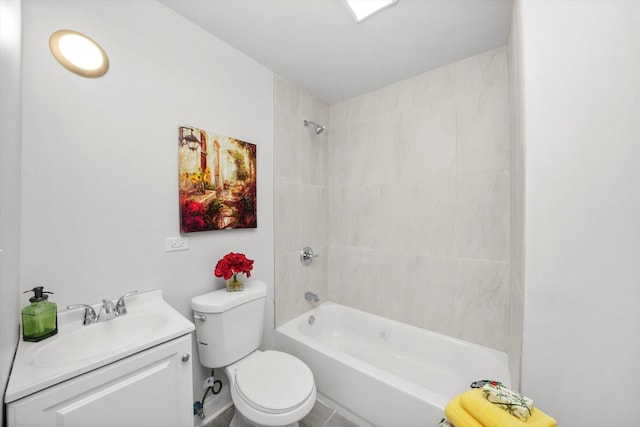 full bathroom with tile patterned floors, vanity, tiled shower / bath combo, and toilet