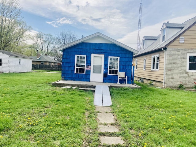 rear view of property with a lawn and an outbuilding