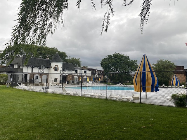 view of pool with a lawn