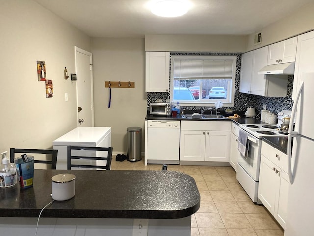 kitchen with white appliances, backsplash, sink, light tile patterned floors, and white cabinetry