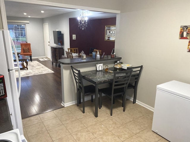 tiled dining room with an inviting chandelier