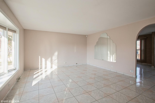 unfurnished room with light tile patterned flooring and a healthy amount of sunlight