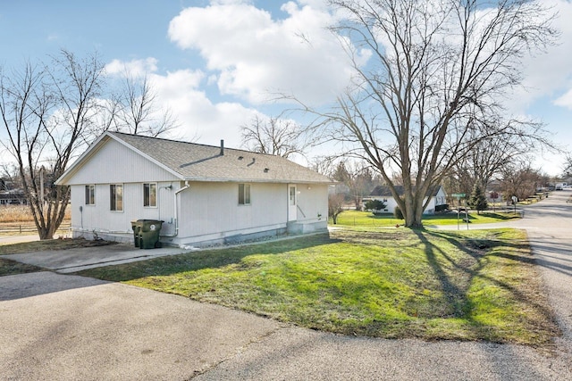 view of side of home with a yard