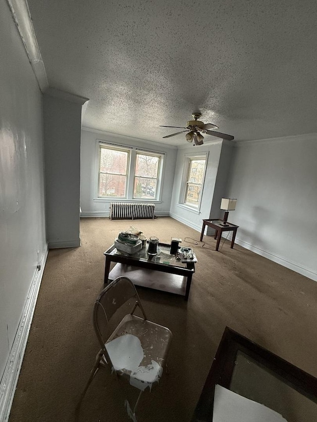 living room with carpet floors, ceiling fan, radiator heating unit, and a textured ceiling