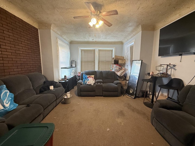 carpeted living room featuring ceiling fan, brick wall, and a textured ceiling