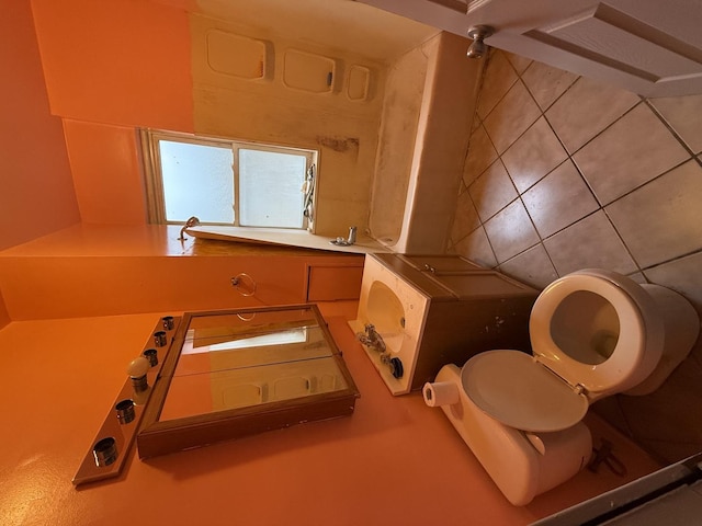 bathroom with backsplash and toilet