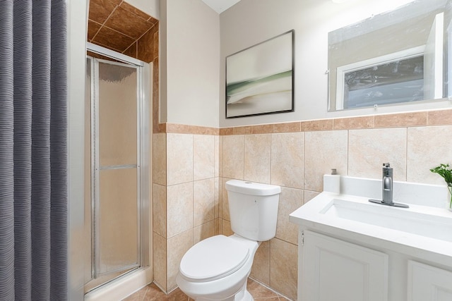 bathroom with tile patterned floors, vanity, toilet, and a shower with door