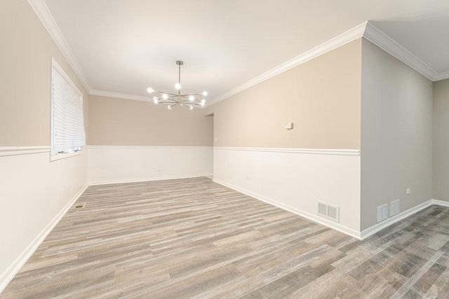 unfurnished room featuring a chandelier, light wood-type flooring, and ornamental molding