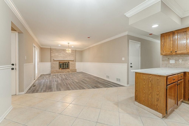 kitchen featuring kitchen peninsula, light tile patterned floors, and a fireplace