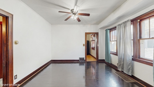 empty room with ceiling fan and dark wood-type flooring