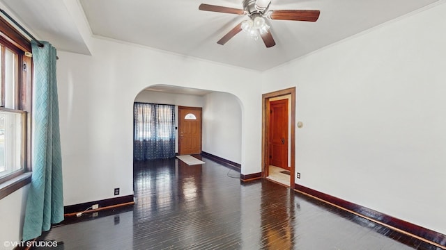 spare room featuring ceiling fan, dark hardwood / wood-style flooring, and crown molding