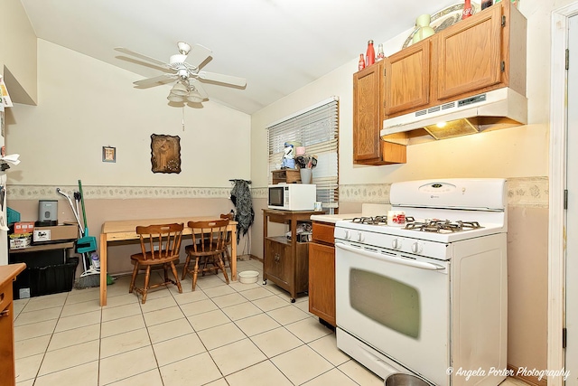 kitchen featuring ceiling fan, white appliances, light tile patterned flooring, and vaulted ceiling