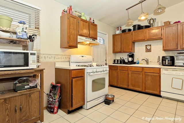 kitchen with pendant lighting, sink, backsplash, light tile patterned floors, and white appliances