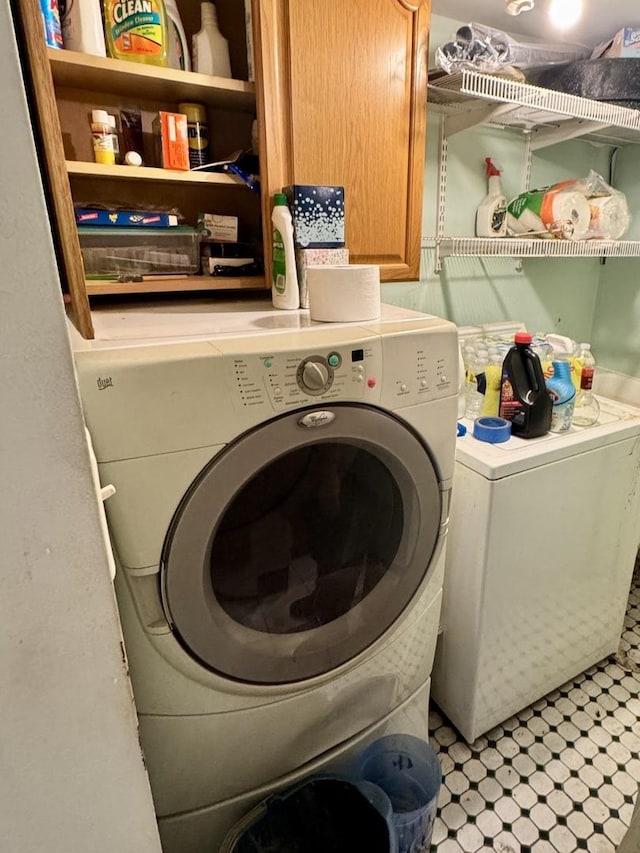 washroom with cabinets and washer and clothes dryer