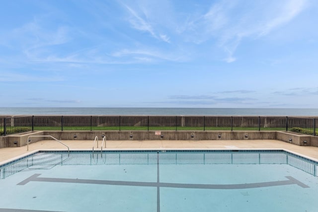 view of swimming pool featuring a fenced in pool, a water view, and fence