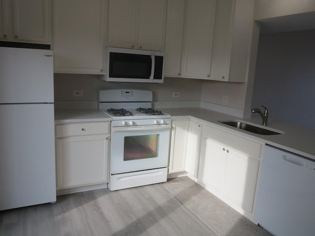 kitchen with light wood-type flooring, white appliances, white cabinetry, and sink