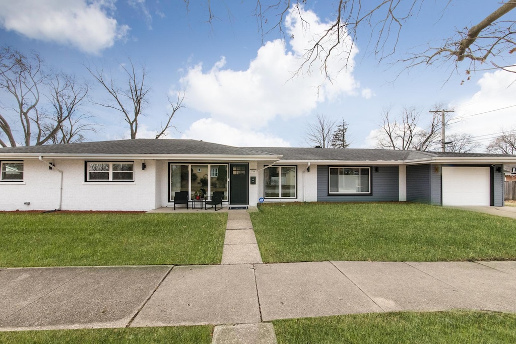 ranch-style home featuring a garage and a front yard