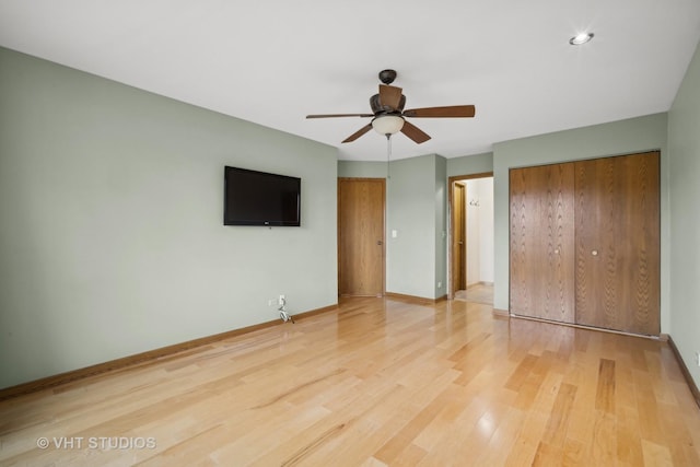 unfurnished bedroom featuring ceiling fan, a closet, and hardwood / wood-style flooring