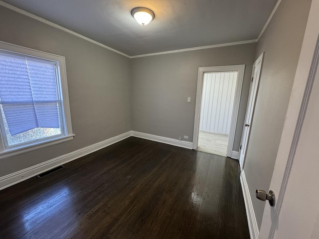 unfurnished room with ornamental molding and dark wood-type flooring