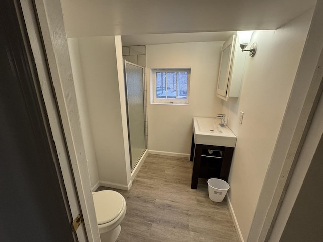 bathroom with toilet, vanity, an enclosed shower, and hardwood / wood-style flooring