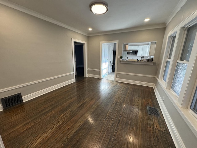 spare room featuring dark wood-type flooring and ornamental molding