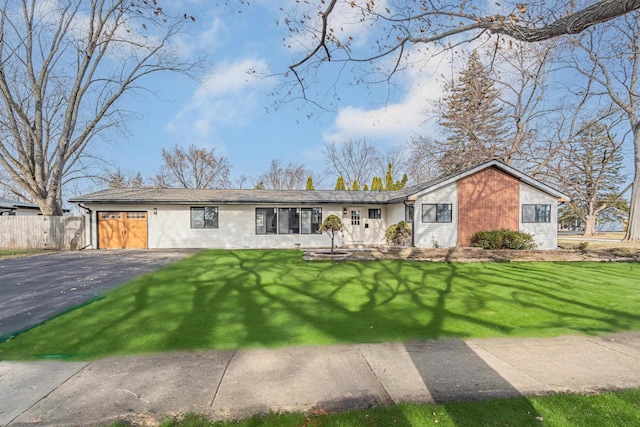 ranch-style house featuring a front yard and a garage