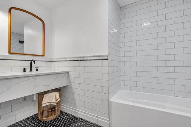 bathroom featuring  shower combination, tile patterned floors, tile walls, and sink