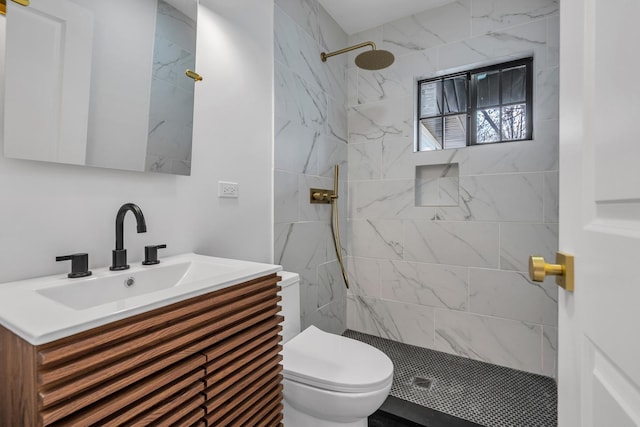 bathroom with vanity, toilet, and a tile shower