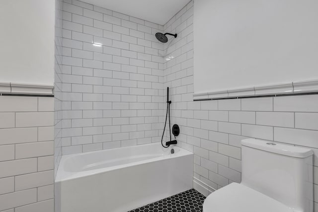 bathroom with tiled shower / bath combo, tile walls, and toilet