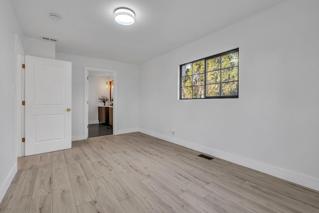 unfurnished bedroom with connected bathroom and light hardwood / wood-style flooring