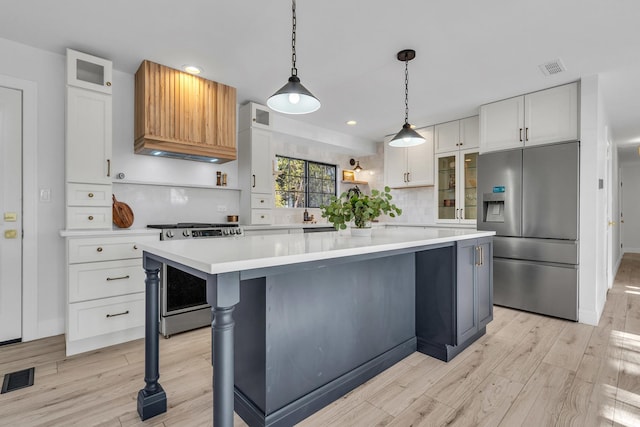 kitchen featuring white cabinetry, pendant lighting, a kitchen island, and stainless steel appliances