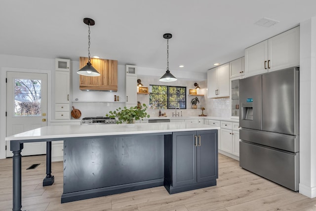 kitchen featuring appliances with stainless steel finishes, white cabinetry, and a large island