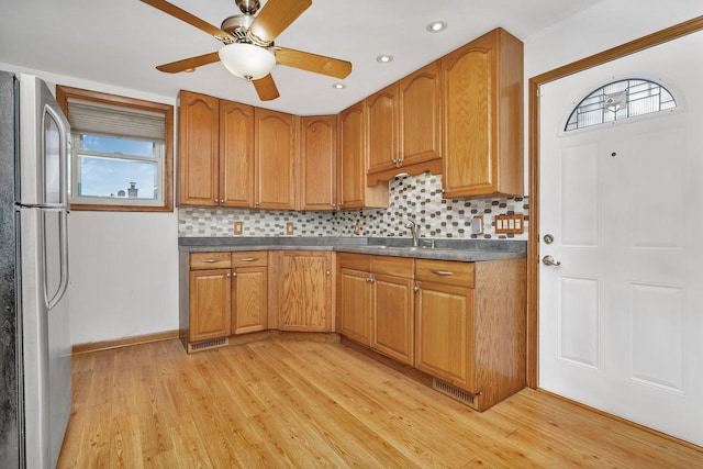 kitchen with tasteful backsplash, stainless steel fridge, light hardwood / wood-style flooring, and ceiling fan