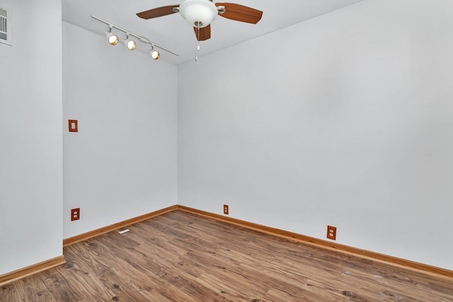 unfurnished room featuring hardwood / wood-style flooring, track lighting, and ceiling fan