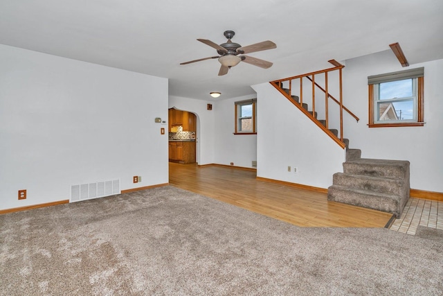 unfurnished living room featuring ceiling fan and carpet